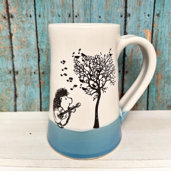 Handmade ceramic mug with drawing of hedgehog playing ukelele